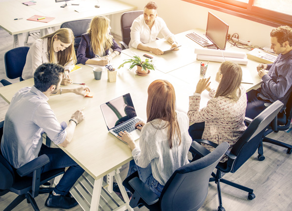 Eine Gruppe von Personen arbeitet an einem Tisch zusammen.